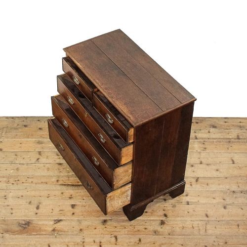 fig 3. A dark mahogany Regency chest of drawers featuring a two-over-three drawer arrangement with oval brass handles and bracket feet.