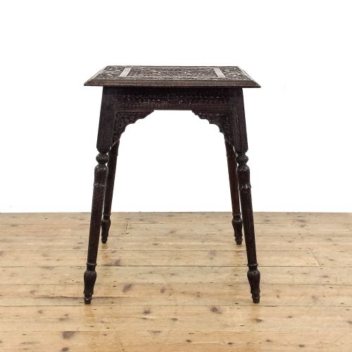 fig 1. A square dark wood side table featuring intricate foliate hand carving across the top, pierced decorative aprons, and turned legs.