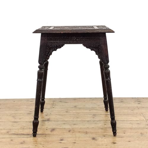 fig 2. A square dark wood side table featuring intricate foliate hand carving across the top, pierced decorative aprons, and turned legs.