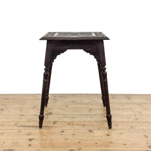 fig 3. A square dark wood side table featuring intricate foliate hand carving across the top, pierced decorative aprons, and turned legs.