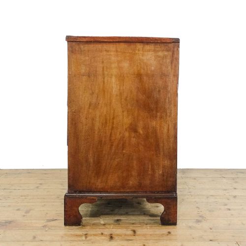 fig 3. An antique 19th-century mahogany chest of drawers featuring two short over three long graduated drawers with brass hardware and bracket feet.