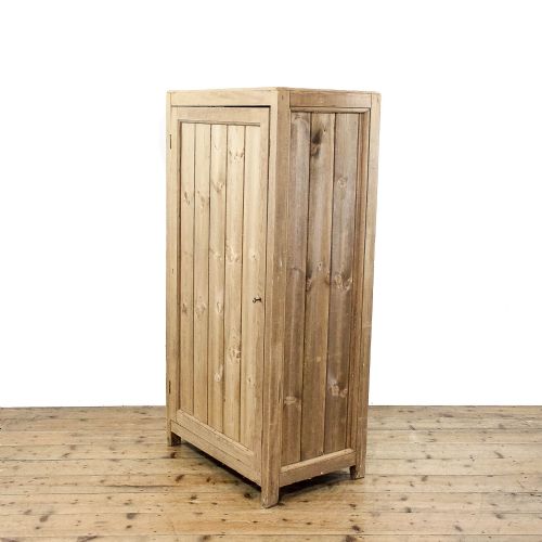 fig 1. A rustic standing pine cupboard with an open single plank door revealing three sections of fitted wooden lattice bottle racks.