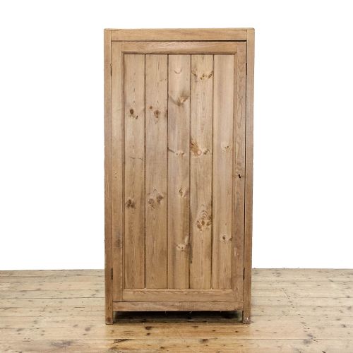 fig 2. A rustic standing pine cupboard with an open single plank door revealing three sections of fitted wooden lattice bottle racks.