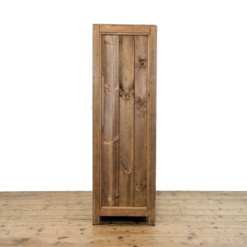 fig 3. A rustic standing pine cupboard with an open single plank door revealing three sections of fitted wooden lattice bottle racks.