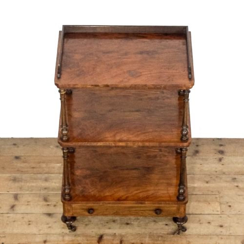 fig 1. A three-tiered Victorian walnut whatnot stand featuring turned support columns, a single base drawer with turned wooden knobs, and brass castors.