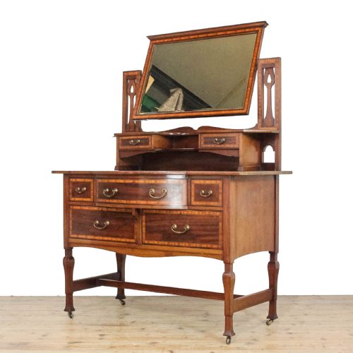 fig 1. An Edwardian mahogany dressing table featuring satinwood marquetry inlay, a central swivel mirror, elevated jewellery drawers, and lower storage drawers with brass drop handles.