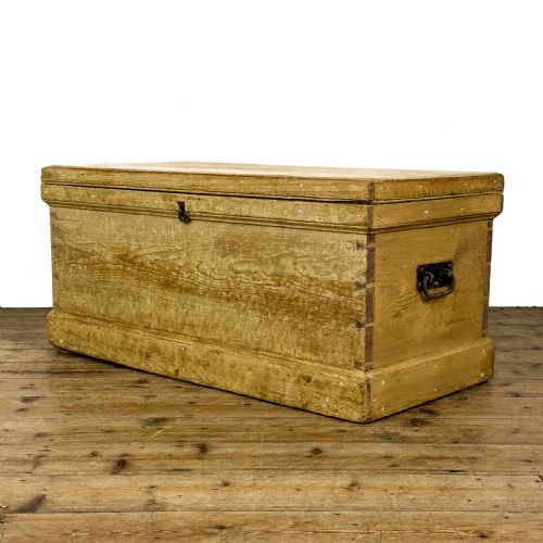 fig 1. A rectangular natural pine blanket box featuring hand-cut dovetail joints, a hinged top lid, a moulded plinth base, and a central metal escutcheon.
