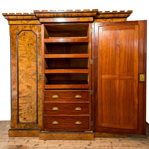 fig 1. A Victorian burr walnut triple compactum wardrobe with an arched central mirrored door flanked by two panelled timber doors and topped with a castellated cornice.