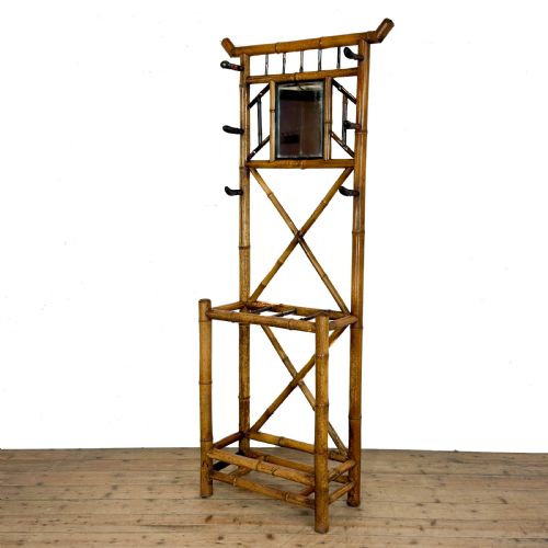 fig 1. A tall Victorian bamboo hall stand featuring a central rectangular mirror, multiple turned coat pegs, cross-braced framing, and an integrated stick stand base.