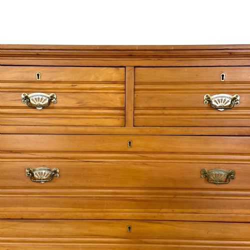 fig 1. An Edwardian pine chest of drawers featuring two short drawers above three long drawers with reeded drawer fronts and brass cup handles.
