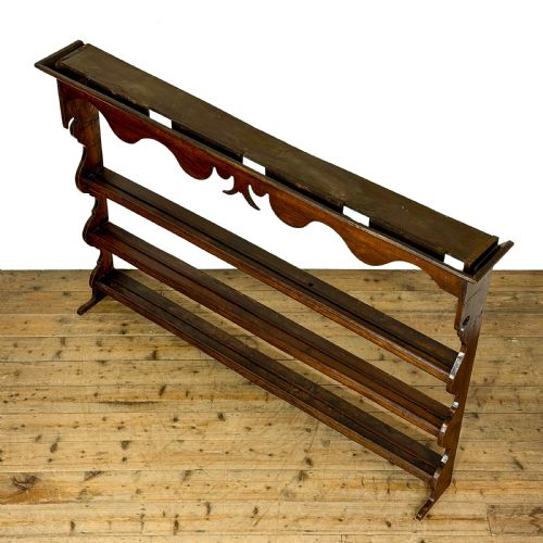 fig 2. A dark oak wooden dresser rack featuring three horizontal shelves and a scalloped top frieze.