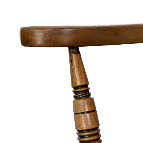 fig 1. A warm brown wooden smokers bow armchair featuring turned legs, vertical back spindles, a steam-bent curved top rail, and a shaped solid seat.