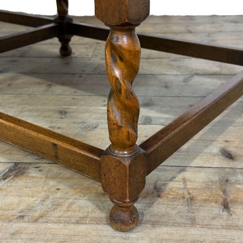 fig 1. An Arts and Crafts style oak hall bench featuring barley twist legs and side posts, a vertical slat backrest, and a terracotta-coloured cushion.
