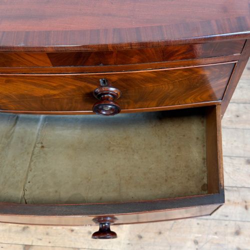 fig 2. A Victorian mahogany bow front chest of drawers with two short over three long drawers, turned wooden knobs, and turned feet.