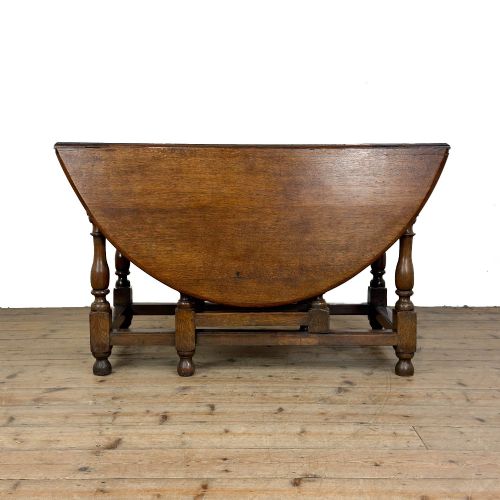 fig 1. An 18th-century dark oak gateleg table featuring two hinged drop leaves, turned legs, and lower stretchers.