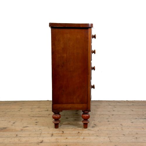fig 1. A Victorian mahogany chest of drawers featuring two short drawers over three long drawers with turned wooden knobs and a scalloped lower apron.