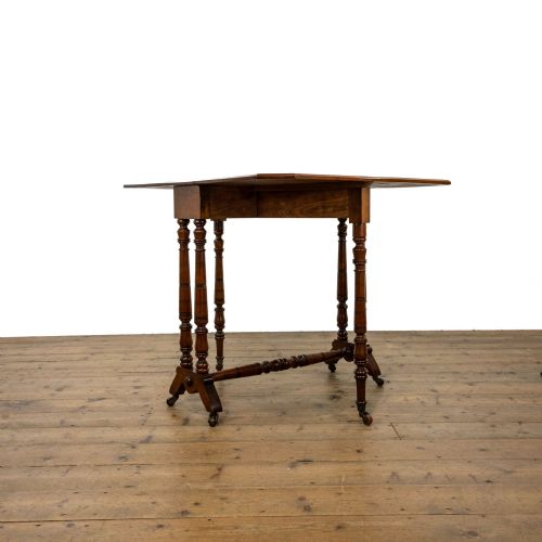 fig 2. An antique Victorian walnut Sutherland table featuring turned legs, a drop-leaf top, a cross stretcher, and small castors.