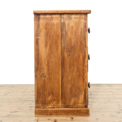 fig 2. An antique pine chest of drawers featuring three wide drawers with turned wooden knob handles and a low plinth base.