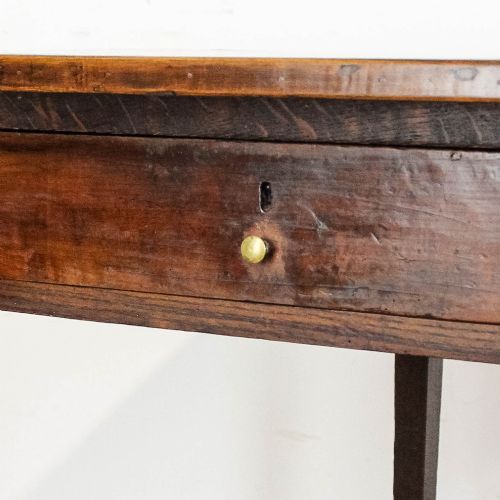 fig 1. An antique dark oak kitchen table featuring a rectangular top, an end drawer with a brass knob, straight legs, and a low H-stretcher base.