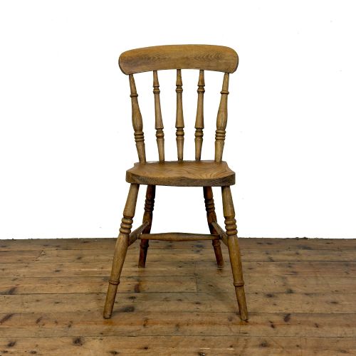 fig 2. A set of six mismatched vintage wooden dining chairs with turned legs and varied slat and spindle backs arranged together.