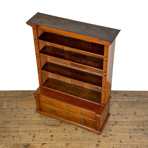 fig 1. A tall antique open bookcase crafted from warm brown walnut featuring multiple open shelves, fluted side pilasters, and two lower drawers with brass drop handles.