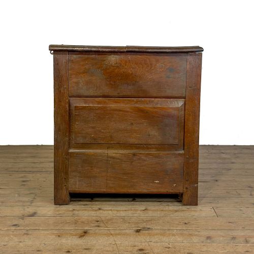 fig 2. A 19th-century warm brown oak coffer featuring three fielded front panels, a brass keyhole escutcheon, and a flat hinged top lid.