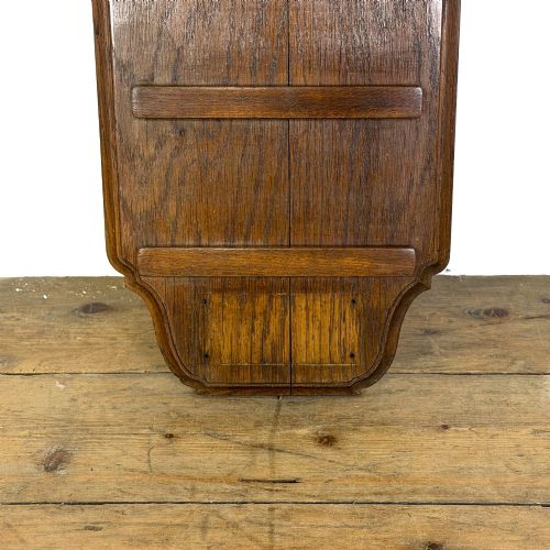 fig 1. An antique solid oak hymn board featuring a pointed arched top with the word HYMNS cut out above five horizontal display slots.
