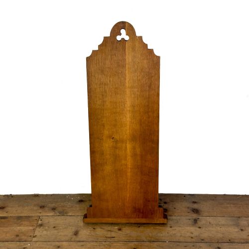 fig 2. An antique dark oak church hymn board featuring a trefoil cutout at the carved top, painted text reading HYMNS, multiple horizontal slots, and an accompanying wooden box.