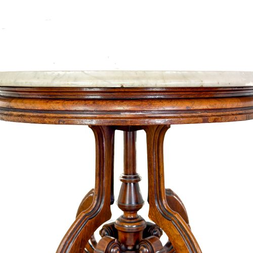 fig 1. A circular Victorian side table featuring a white marble top supported by a carved mahogany pedestal base with scrolled legs.