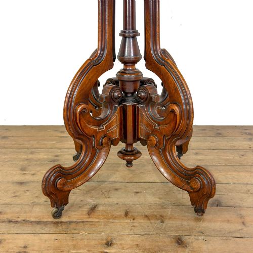 fig 2. A circular Victorian side table featuring a white marble top supported by a carved mahogany pedestal base with scrolled legs.