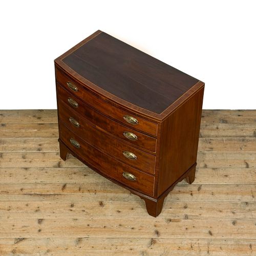 fig 2. An antique Georgian mahogany bow-front chest of drawers with four graduated drawers and brass oval drop handles.