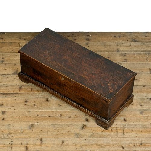 fig 1. A rectangular George III dark elm blanket chest with a hinged lid, brass escutcheon, and bracket feet.