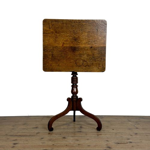fig 2. A 19th-century oak tilt-top table featuring a rectangular surface set upon a turned central column with three cabriole tripod legs.
