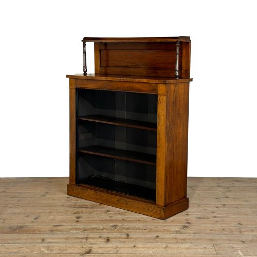 fig 1. An antique rosewood open bookcase featuring a raised back gallery flanked by turned columns, with three open shelves and a beaded trim.