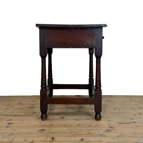 fig 2. An 18th-century dark oak side table featuring a single drawer with turned wooden knobs, turned front legs, and lower stretchers.