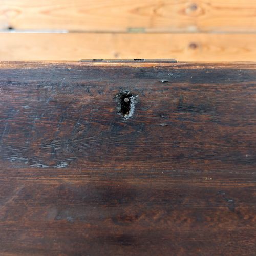 fig 1. An antique stained pine blanket box featuring a flat hinged lid, dark wood finish, moulded plinth base, and central keyhole escutcheon.
