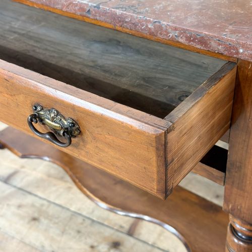 fig 1. An Edwardian wooden washstand with a carved splashback housing floral glazed tiles, a single drawer with drop handles, turned legs, and an undertier shelf.