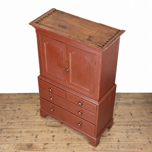 fig 1. A tall Victorian painted pine housekeepers cupboard in a terracotta red finish, featuring a double-door upper cabinet over two short and two long drawers.