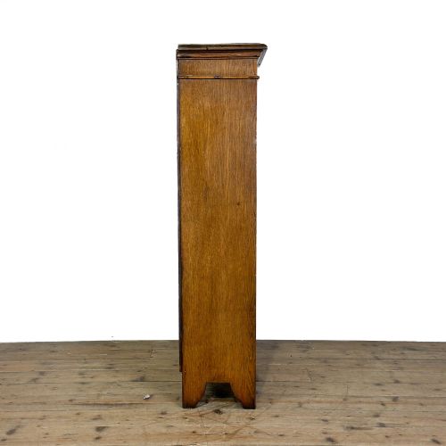 fig 1. An open antique oak bookcase featuring four wooden shelves, a upper moulded cornice, vertical pine backboards, and shaped bracket feet.