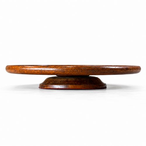fig 1. A circular dark oak revolving tray featuring a raised moulded lip and a broad pedestal base.