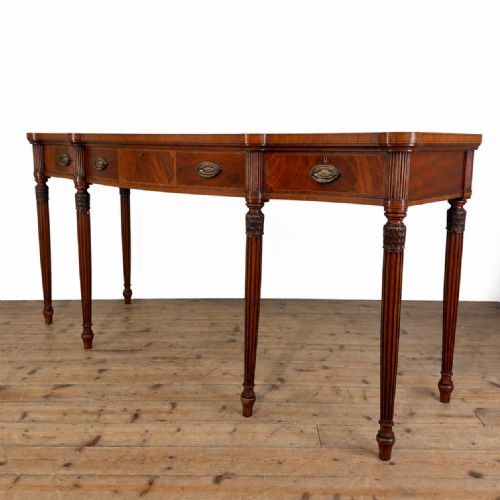 fig 1. An Edwardian mahogany serving table featuring inlaid drawer fronts, brass oval handles, and slender fluted tapered legs.