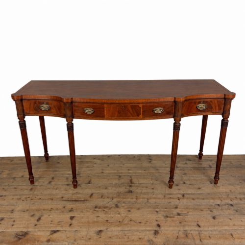 fig 2. An Edwardian mahogany serving table featuring inlaid drawer fronts, brass oval handles, and slender fluted tapered legs.