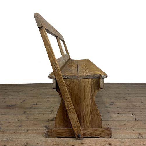 fig 1. A long pine chapel bench featuring a reversible flip-over backrest and solid wooden side supports on a timber floor.