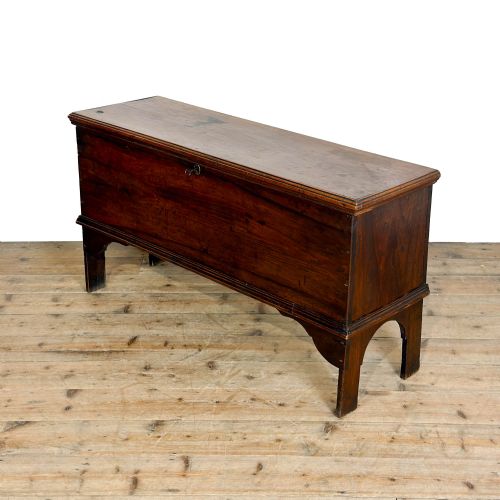 fig 2. A rectangular dark brown elm six-plank coffer featuring a hinged lid, keyhole escutcheon, and cut-out shaped feet.