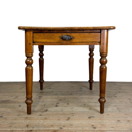 fig 2. A Victorian warm brown pine kitchen table featuring turned legs and a single drawer at one end.