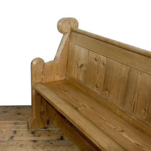 fig 2. A freestanding antique pine chapel pew featuring a panelled backrest, solid bench seat, and carved upright side supports.
