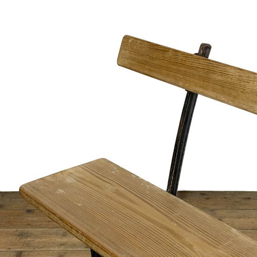 fig 1. An antique railway bench featuring a natural pine wood seat and backrest supported by a dark cast iron frame.