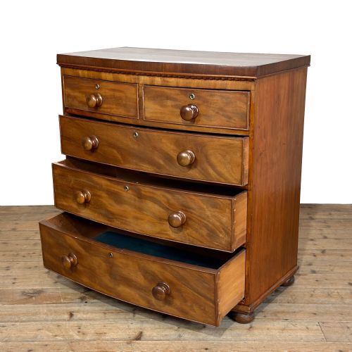 fig 1. A nineteenth-century mahogany bow-front chest of drawers featuring two short over three long graduated drawers with turned knob handles.