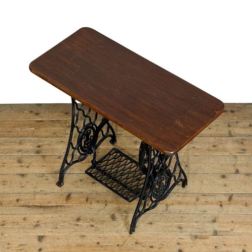 fig 2. A black cast iron Singer treadle sewing machine base fitted with a flat rectangular wooden tabletop.
