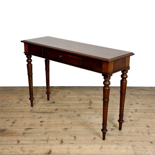 fig 1. An antique dark mahogany hall table featuring a single central drawer with a round knob handle and four slender turned legs.